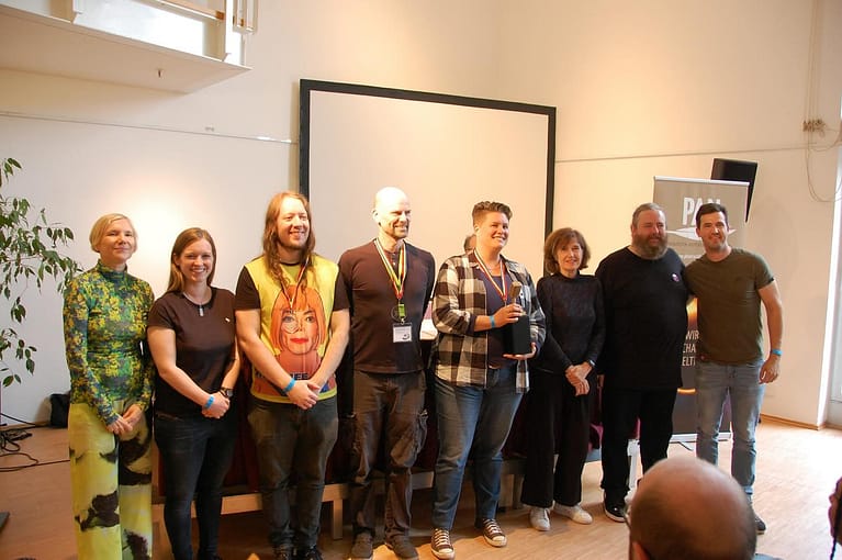 Die Vortragenden des Poetry Slam Contest auf der BuCon, stehen für ein Foto in einer Reihe. Die Gewinner in der Mitte.